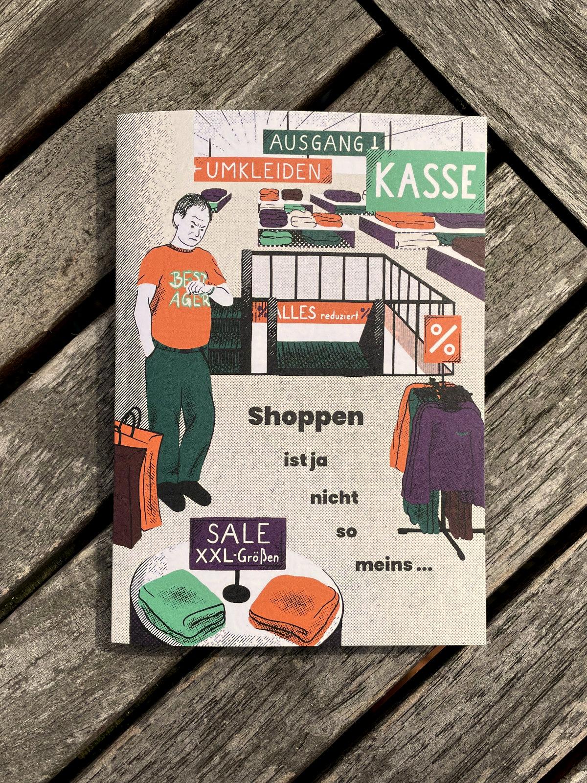 Eine illustrierte, gefaltete Geburtstagseinladung liegt auf einem Tisch. Die Karte zeigt einen Mann in einem Kaufhaus, der unzufriedend wartend auf seine Armbanduhr schaut.